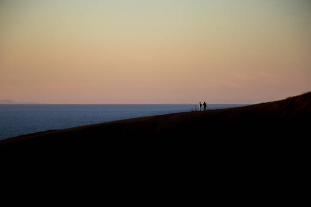 silhueta do casal que tira a foto do oceano - sunrise beach couple hiking - fotografias e filmes do acervo