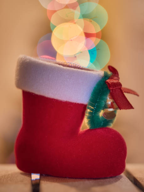 istock small red Santa's boot, on old wood, with bokeh background 1443979212