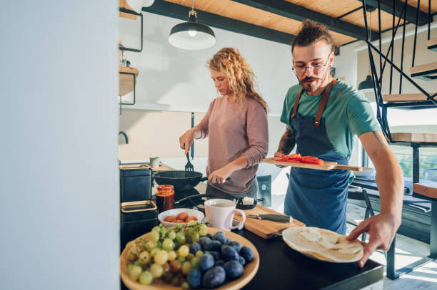 istock Young couple making breakfast together in the kitchen at home 1443981351