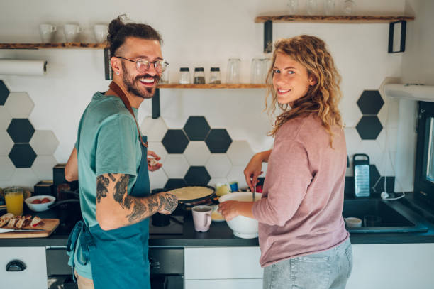 istock Young couple making breakfast together in the kitchen at home 1443981356