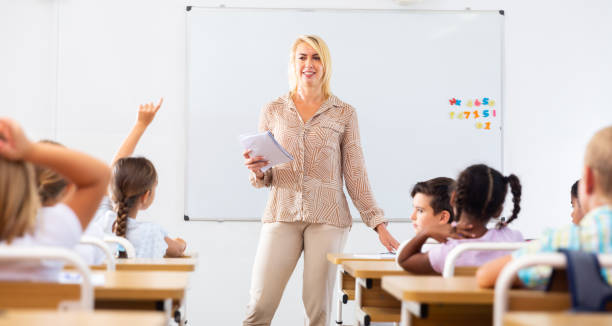 istock Woman teacher lecturing to pupils at classroom 1443985158