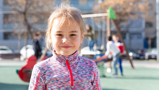 Portrait of positive little girl at the playground