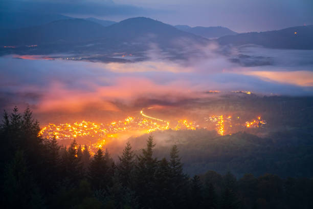 on the edge of an inversion in the black forest, the golden lights of the small village of michelbach light up the night - forest black forest sky night imagens e fotografias de stock