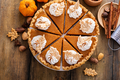 Traditional Thanksgiving pumpkin pie cut into slices overhead view