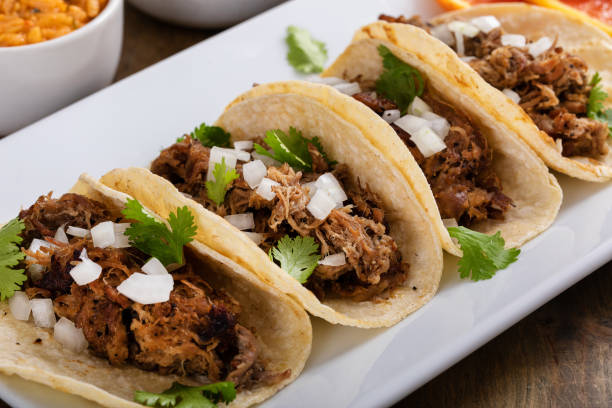 istock Pork carnitas tacos on corn tortillas with rice and beans 1443991736