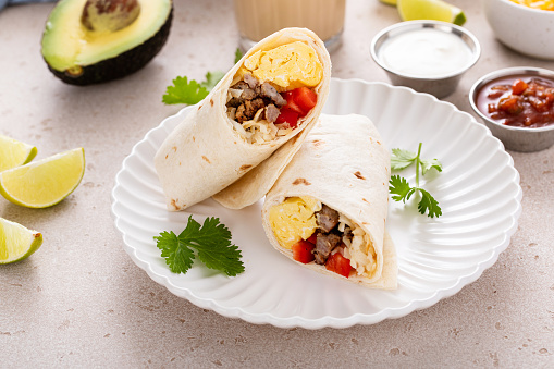 Breakfast burrito with sausage, scrambled eggs, bell pepper and cheese
