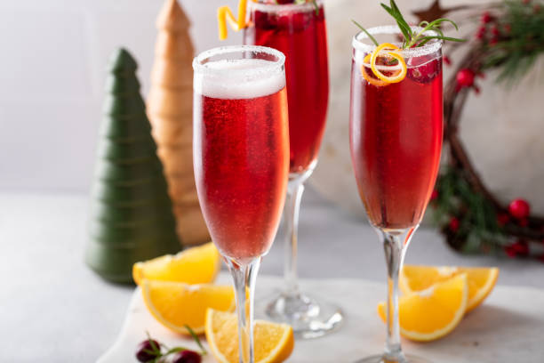 Christmas mimosa with cranberry juice and orange Christmas mimosa with cranberry juice and orange, garnished with rosemary, festive cocktail idea carbonated juice stock pictures, royalty-free photos & images