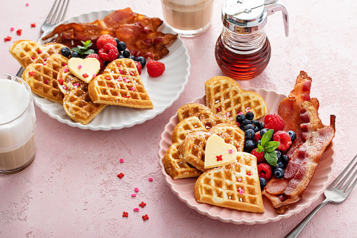 Valentines day breakfast for two with heart shaped waffles and bacon