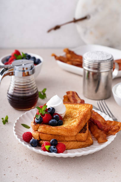 Classic french toast with bacon and berries Classic french toast with bacon and fresh berries topped with whipped cream french toast bacon bread butter stock pictures, royalty-free photos & images