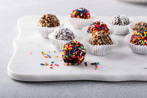Homemade chocolate truffles with dark chocolate ganache covered with sprinkles, coconut and nuts