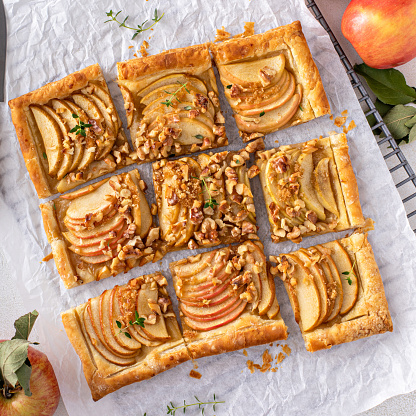 Apple tart with puff pastry tpped with sliced apples, walnuts and brown sugar caramel sliced into squares