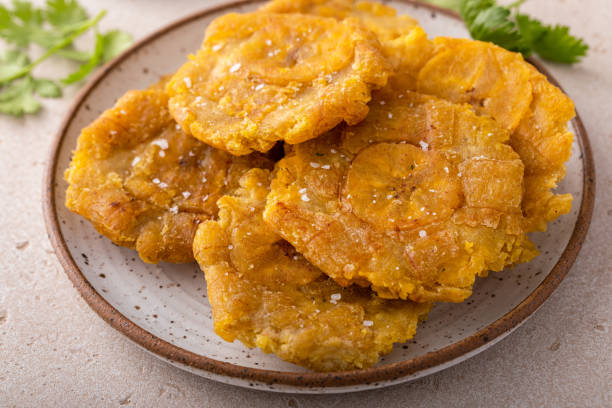 Tostones, traditional Carribean dish, twice fried plantains Tostones, traditional Carribean dish, twice fried green plantains plantain stock pictures, royalty-free photos & images