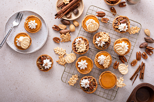 Mini pumpkin and pecan pies baked in muffin tin, traditional Thanksgiving or fall dessert