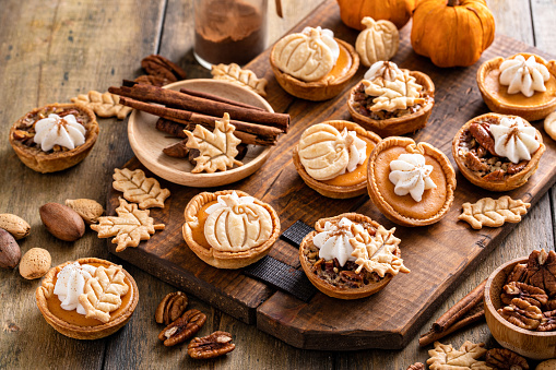 Mini pumpkin and pecan pies baked in muffin tin, traditional Thanksgiving or fall dessert
