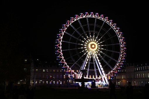 Colorfull ferris wheel at night in europe on the main square near Christmas market with soft focus