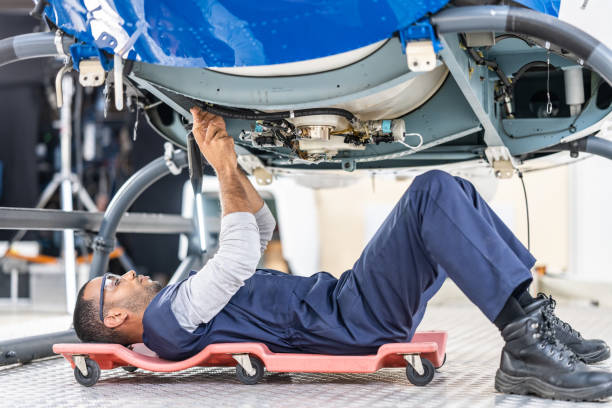 istock African American aviation engineer lying on roller creeper and repairing helicopter 1444003824
