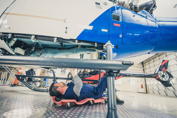 istock Aviation engineer lying on repair lounger and examining helicopter engine 1444003825