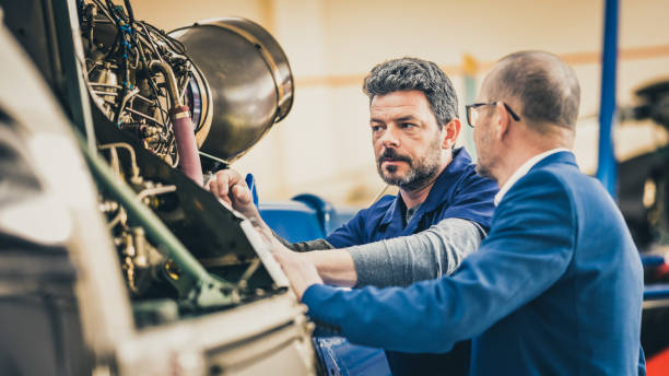 istock Helicopter hangar worker chatting with businessman 1444003851
