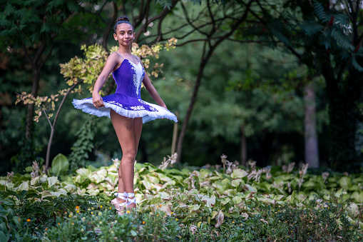 Ballet dancer posing in the city park.