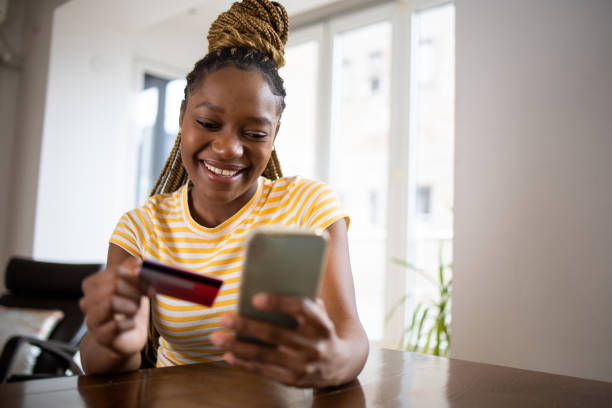 istock Cheerful  woman doing online shopping 1444004962