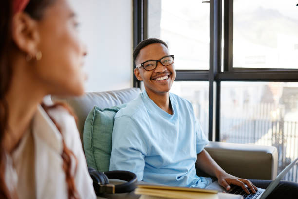 istock Happy students, teamwork or education man with smile on laptop in school, college or university classroom. Smiling, laughing or excited male on sofa for learning, study or comic conversation in Miami 1444021521