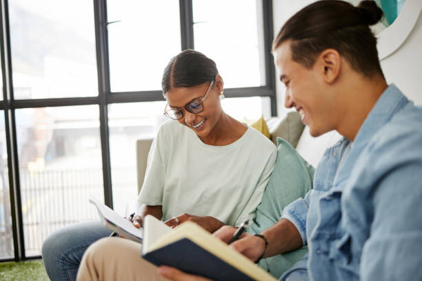 istock Studying, university and couple students learning together in campus lounge for knowledge, education and project planning. Young college people, notebook and course information for scholarship letter 1444021598