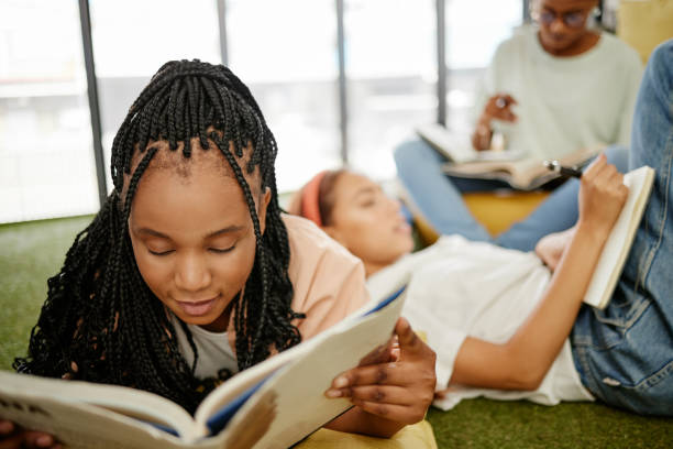 istock Education, study and learning students group of people studying for test, exam or doing research project on school campus. University, young college friends or a relax gen z black woman reading books 1444021641