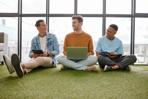 istock Laptop, tablet and businessmen in creative office working online for startup career. Work, business and digital technology in ecofriendly workplace. Team of men talking on floor in workspace 1444021726