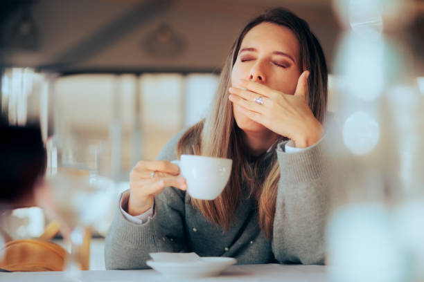 mulher sonolenta tomando um café no restaurante - dependency caffeine tired women - fotografias e filmes do acervo