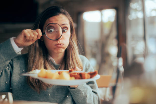 Funny Food Critic Checking the Restaurant Dish with a Magnifying Glass stock photo