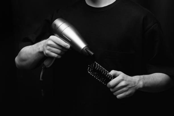 sèche-cheveux et peigne dans les mains du barbier - head massage audio photos et images de collection