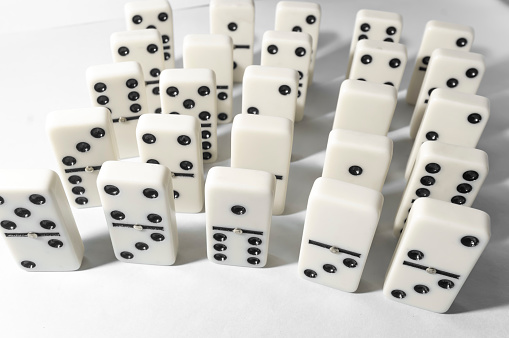 Domino pieces with white background, copy space and various agulos, concept of table games