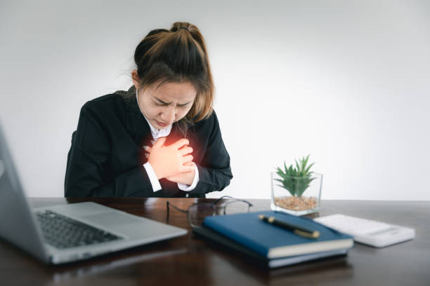 가슴을 만지고 컴퓨터에서 오랜 시간 일한 후 가슴 통증이 있는 여자. 사무실 증후군, 아시아인의 심장마비 질환에서 직업적 소진 스트레스 증후군의 위험 개념. - pulse trace human cardiovascular system heart shape heart disease 뉴스 사진 이미지