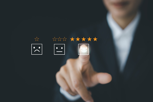 Business people touching the virtual screen on the happy Smiley face icon to give satisfaction in service. Customer service and Satisfaction concept, rating very impressed.