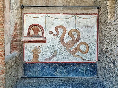 Pompeii, Campania, Italy - October 14, 2021: Fresco with snake in the House of the Cryptoporticus in Via dell'Abbondanza in the Archaeological Park of Pompeii