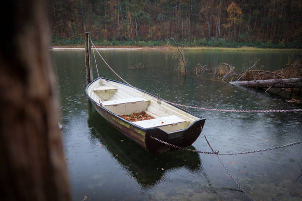 istock a rowboat is lying in the rain on the lake 1444050335