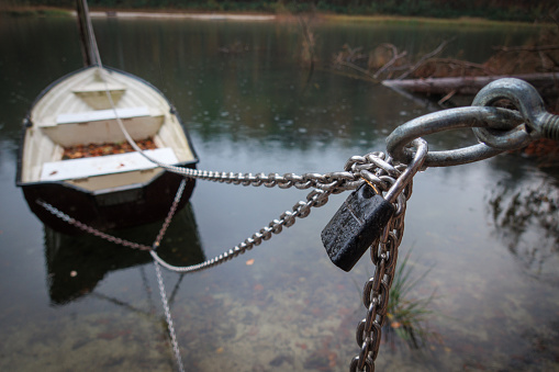 Rowing boats an a lake are secured with a chain and a padlock
