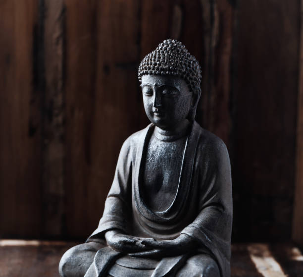 istock Meditating Buddha Statue on dark wooden background. Close up. Copy space. 1444056351