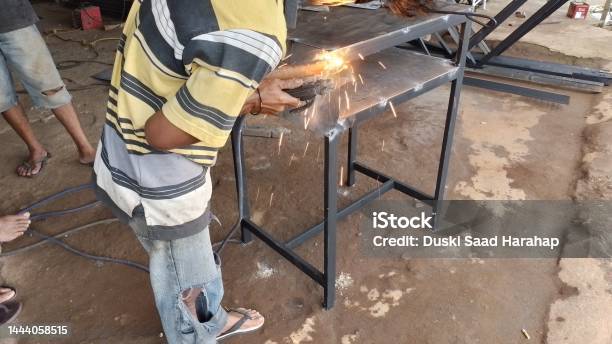 Workers Welding Iron Parts At Work With Side Angle Stock Photo - Download Image Now - Adult, Adults Only, Blue