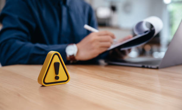 Warning sign on table in front of businessman Caution in investing Economic situation warning, Deflation and  inflation concept stock photo