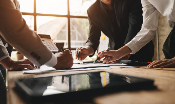istock Business documents on office table with smart phone and calculator digital tablet and graph business with social network diagram and two colleagues discussing data working in the office 1444063497