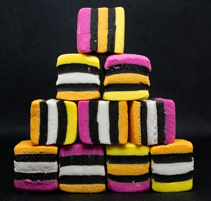 A four tiered pyramid of colorful licorice candy isolated on black background, closeup