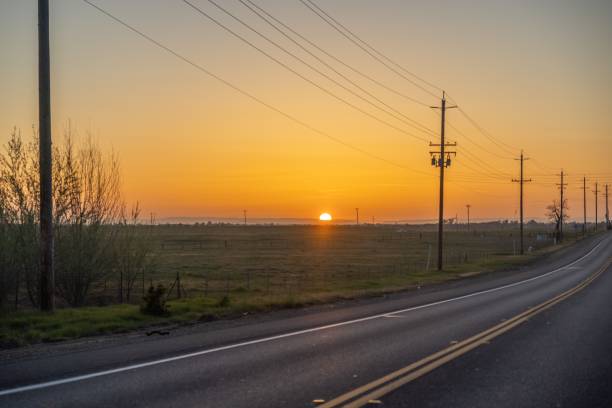 istock Scenic sunset over the field behind the road 1444065973