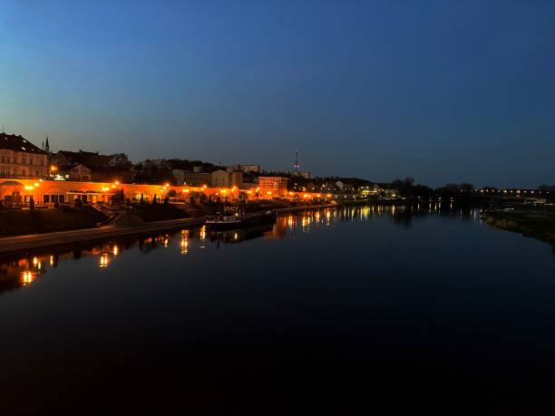 istock Beautiful town with lights next to a calm lake during nighttime 1444067506