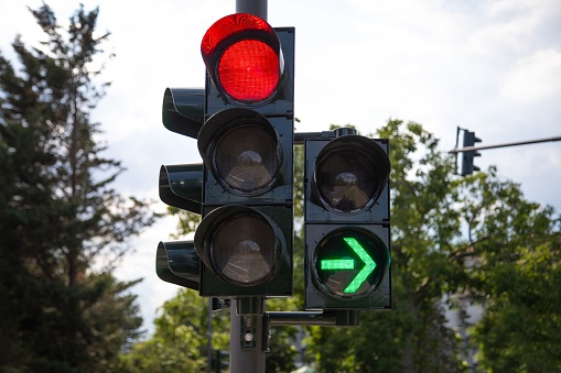 A closeup of red traffic light with green arrow light up allow by law to turn right