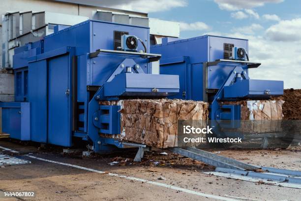 Paper Squeezer Container And A Garbage Press Machine Recycle Cardboard Into Reusable Material Bales Stock Photo - Download Image Now