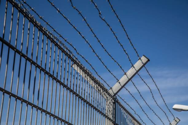 istock Barbed wire fence outdoors 1444068523