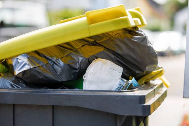 istock Full garbage trash can with ffp2 face mask standing at sidewalk 1444068783