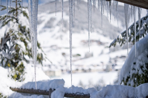 A selective focus shot of icicles hanging from the roof