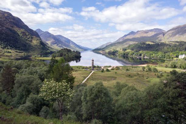 A valley, a monument and a lake in Scottish Highlands Glenfinnan Monument on the shore of Loch Shiel in Highlands, Scotland glenfinnan monument stock pictures, royalty-free photos & images